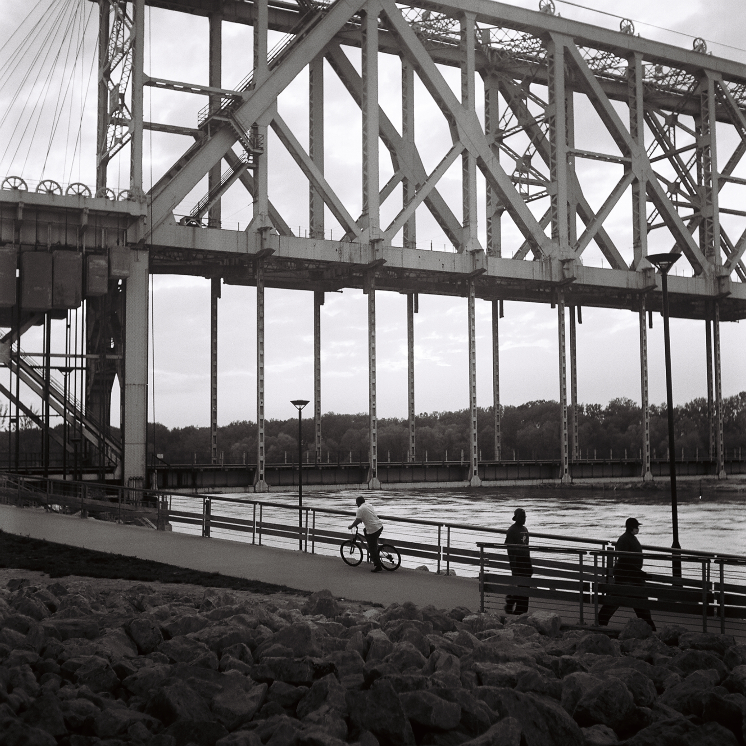 A person riding a bike with a bridge in the back